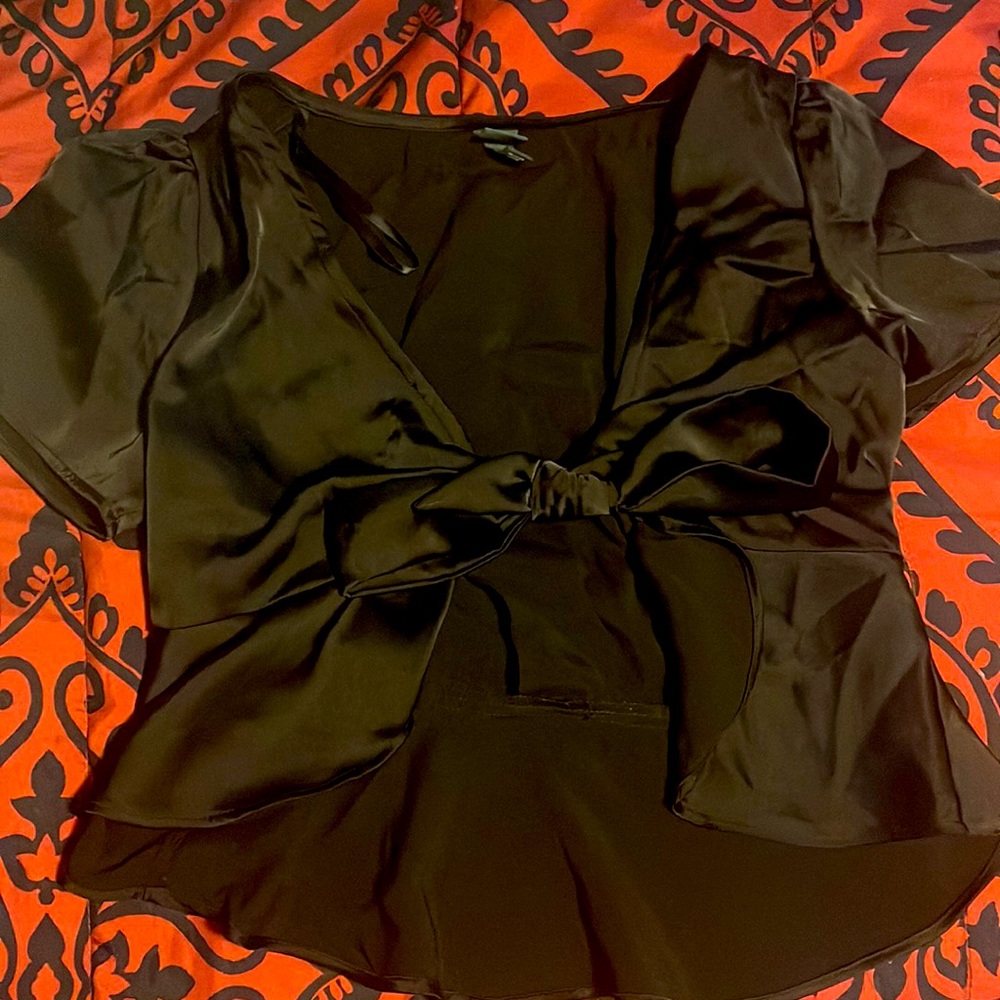 A tie crop top . Color black it has a silky fabric